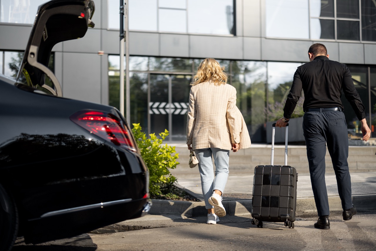 Chauffeur helping guest with luggage for family pickups and airport transfers